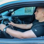 A person with hands on wheel